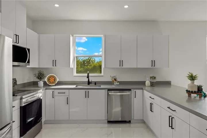Kitchen featuring sink, white cabinetry, and stainless steel appliances