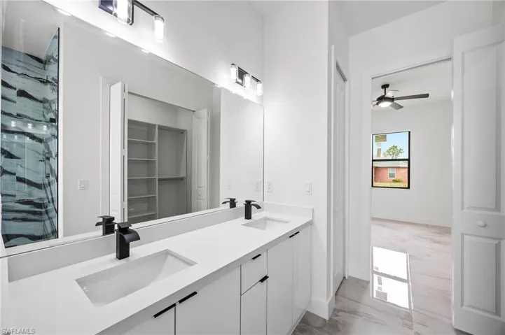 Bathroom with vanity, ceiling fan, and a shower with shower door