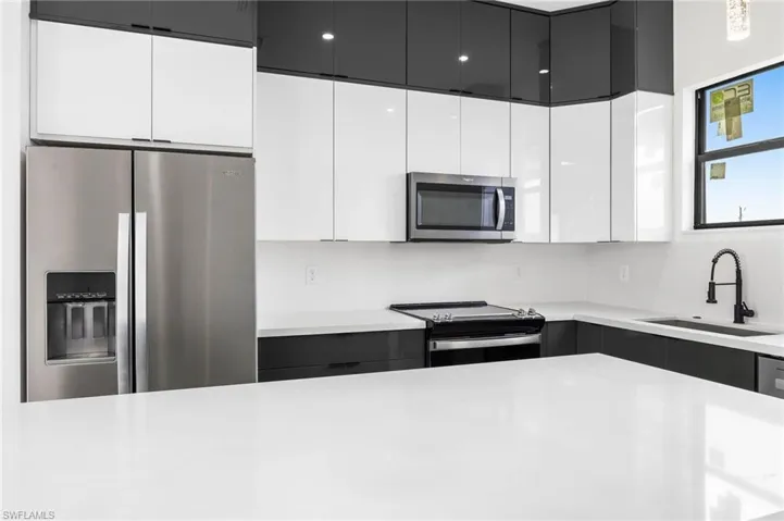 Kitchen with white cabinets, stainless steel appliances, and sink