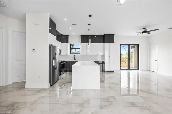Kitchen with ceiling fan, a center island, sink, stainless steel fridge with ice dispenser, and pendant lighting