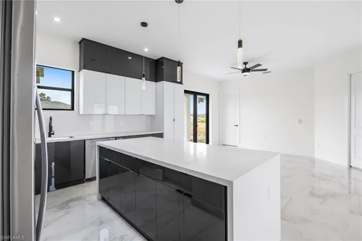 Kitchen featuring plenty of natural light, a center island, hanging light fixtures, and ceiling fan
