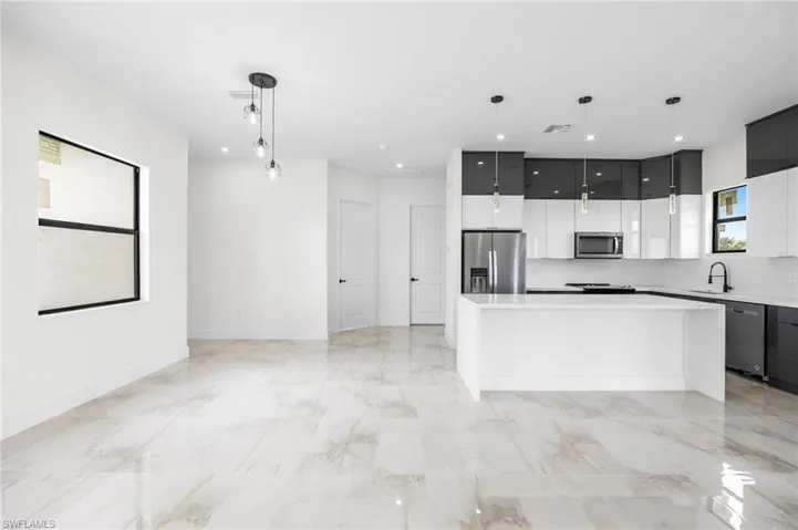 Kitchen featuring sink, a center island, pendant lighting, and appliances with stainless steel finishes