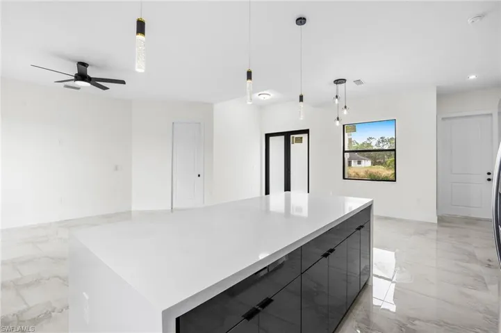 Kitchen featuring ceiling fan, a spacious island, and hanging light fixtures