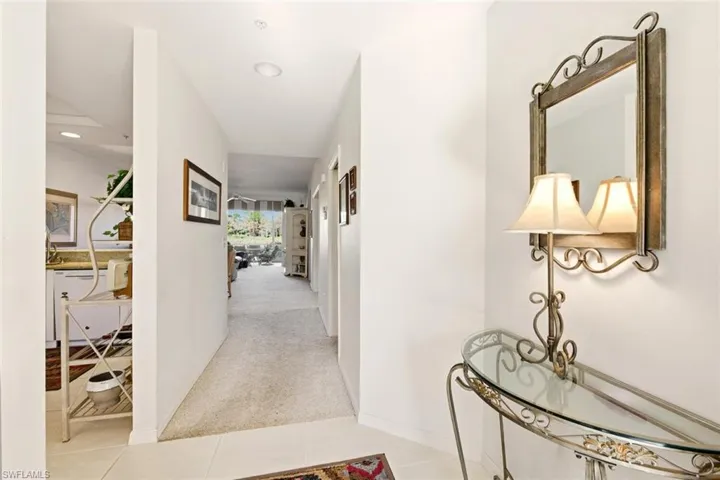 Corridor with light colored carpet, recessed lighting, and light tile patterned floors