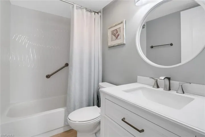 Full bathroom with shower / bathtub combination with curtain, vanity, and toilet