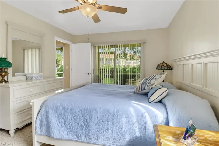 Bedroom featuring multiple windows, access to outside, ceiling fan, and light colored carpet
