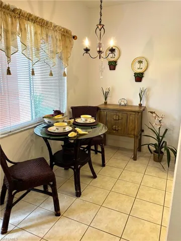 Tiled dining space featuring a notable chandelier