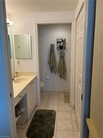 Bathroom featuring a textured ceiling, vanity, toilet, and tile patterned floors