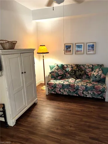 Living room featuring dark wood-type flooring and ceiling fan