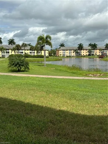 View of home's community featuring a water view and a yard