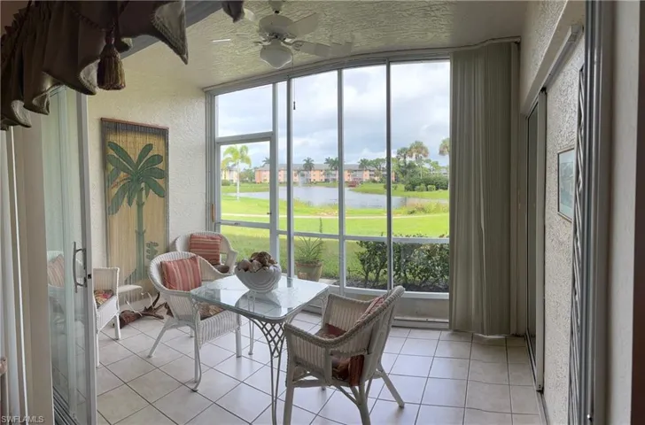 Sunroom featuring plenty of natural light, a water view, and ceiling fan