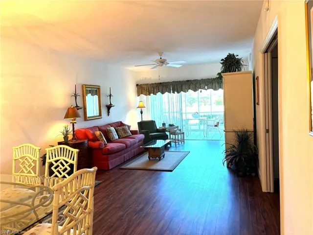 Living room with dark hardwood / wood-style floors and ceiling fan