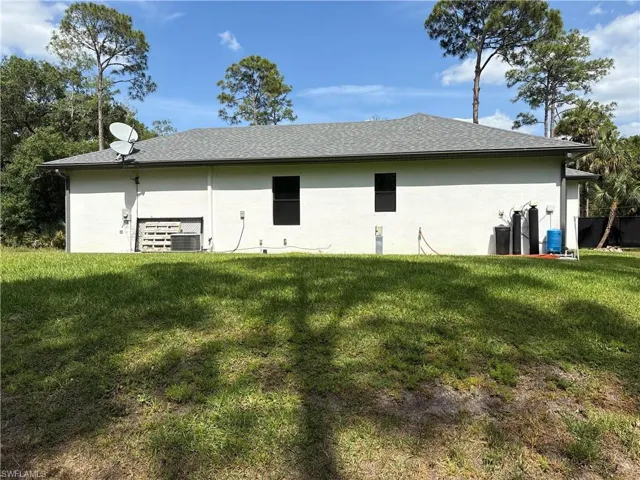 View of side of home featuring a yard and stucco siding