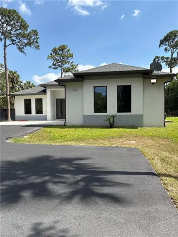 Prairie-style home with stucco siding and a front lawn