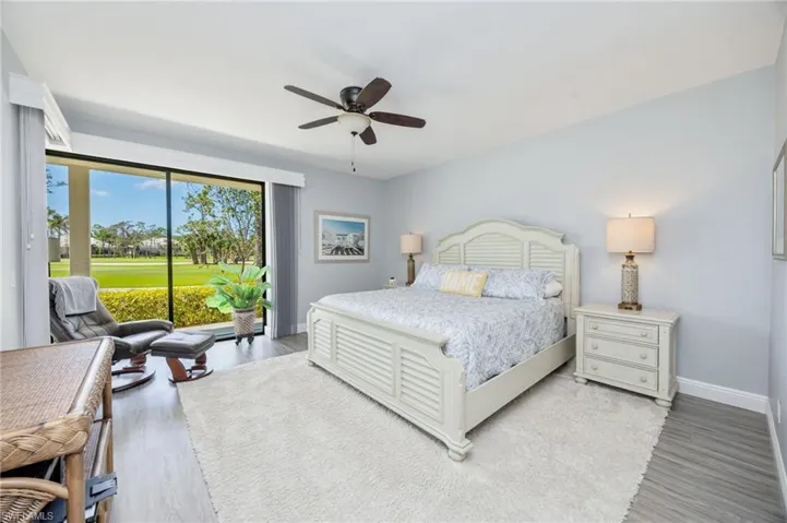Bedroom featuring access to outside, a ceiling fan, light wood-style floors, and view of golf course