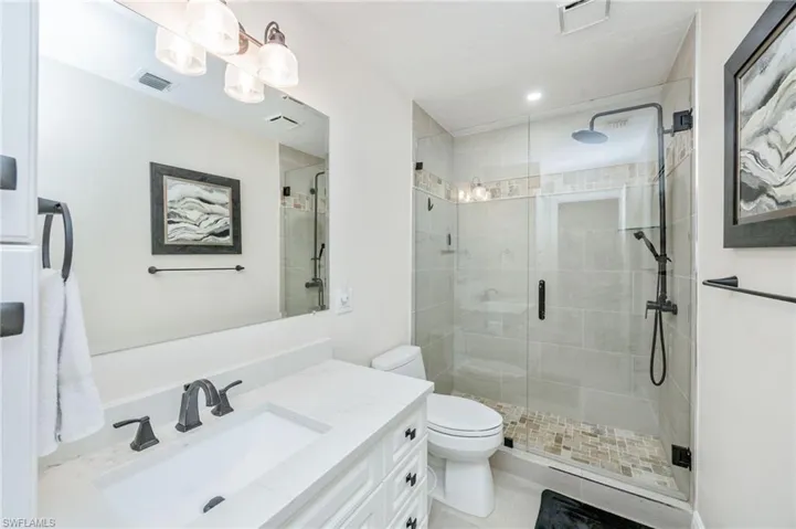 Bathroom featuring vanity and a shower stall