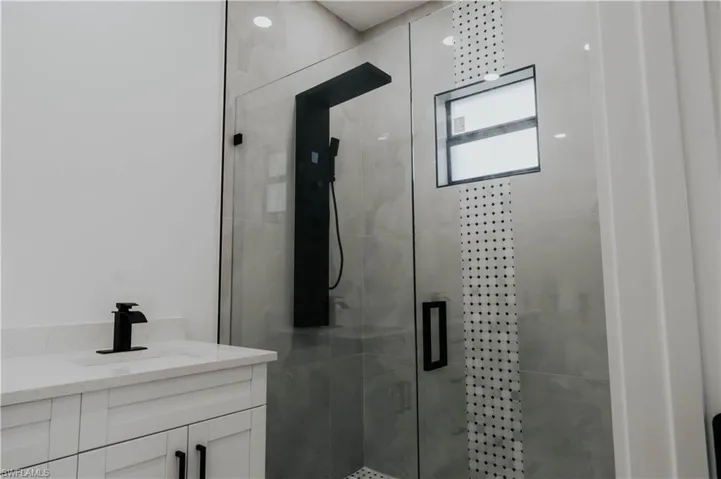 Bathroom featuring vanity and a shower stall