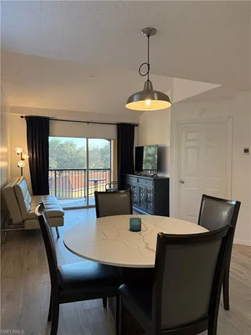 Dining room featuring a textured ceiling, wood-type flooring, and heating unit