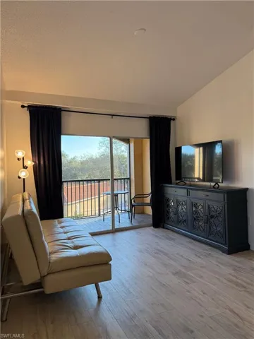 Bedroom with access to exterior and wood finished floors