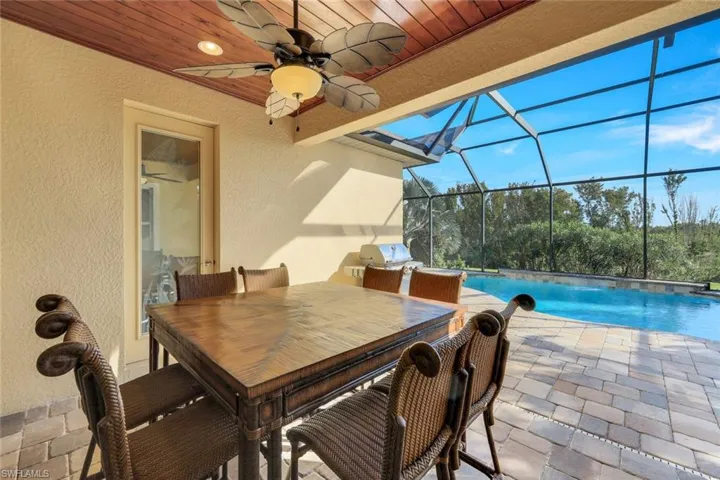 View of patio / terrace featuring an outdoor pool, a lanai, a sunroom, outdoor dining area, and a ceiling fan