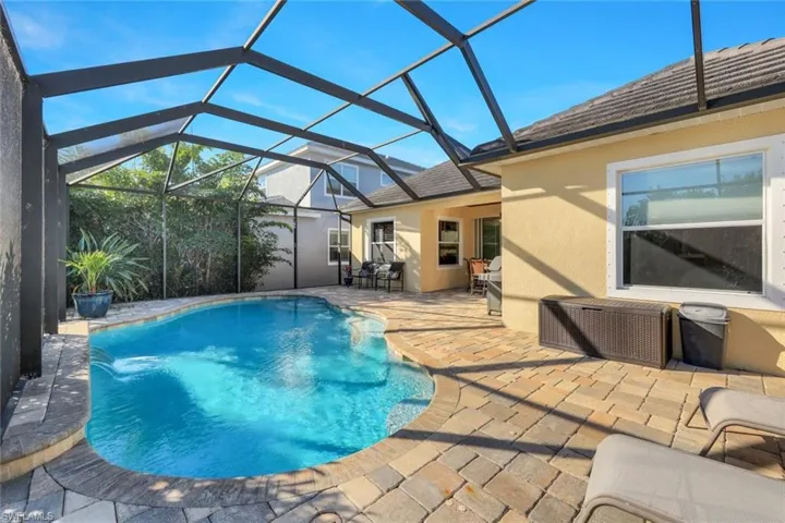 Swimming pool featuring a patio, a lanai, and a sunroom