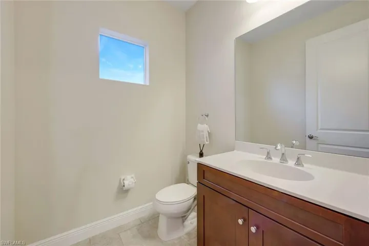 Half bathroom featuring vanity and light tile patterned flooring