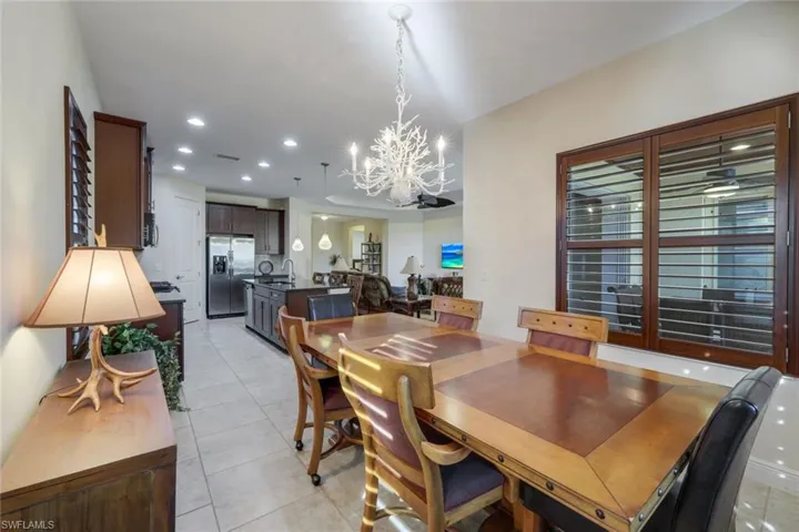 Dining room featuring light tile patterned floors, recessed lighting, and a chandelier