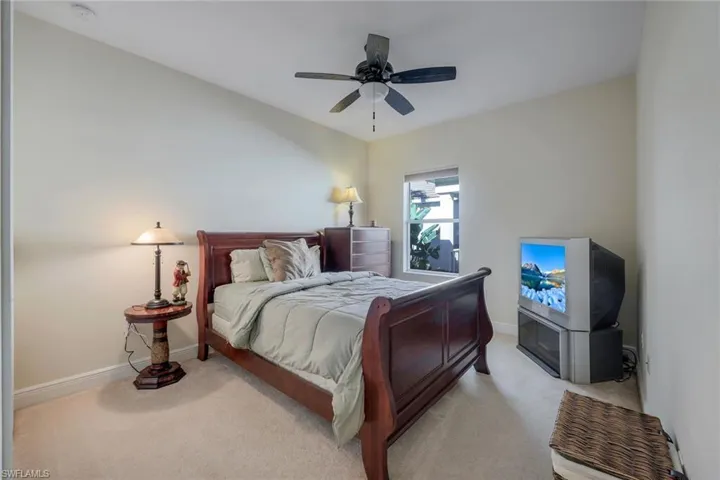Carpeted bedroom with baseboards and a ceiling fan