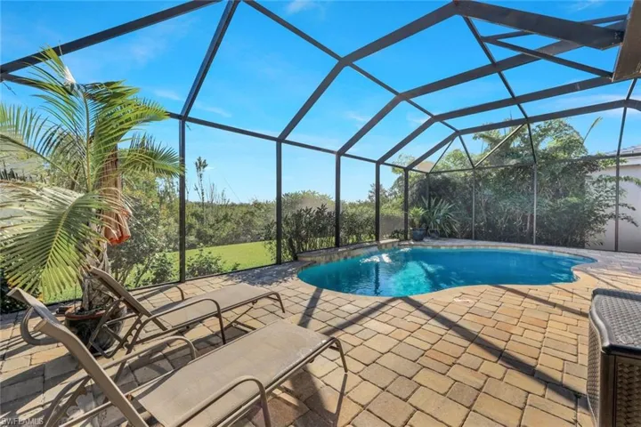 Outdoor pool featuring a lanai, a sunroom, and a patio area
