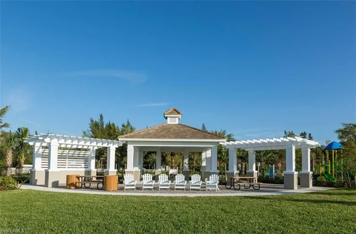 View of community featuring a pergola, a patio area, and a lawn