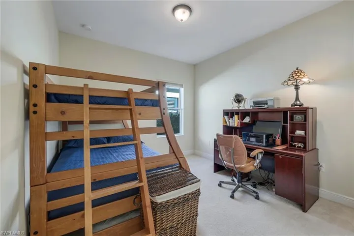 Bedroom with an office area and carpet flooring