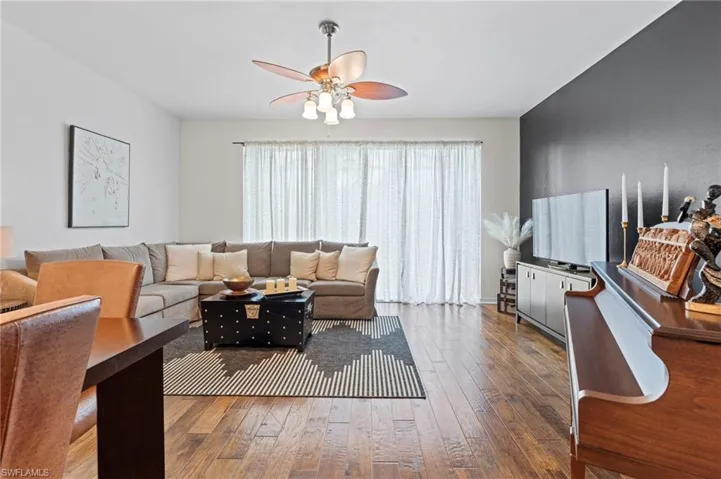 Living room with wood-type flooring and ceiling fan