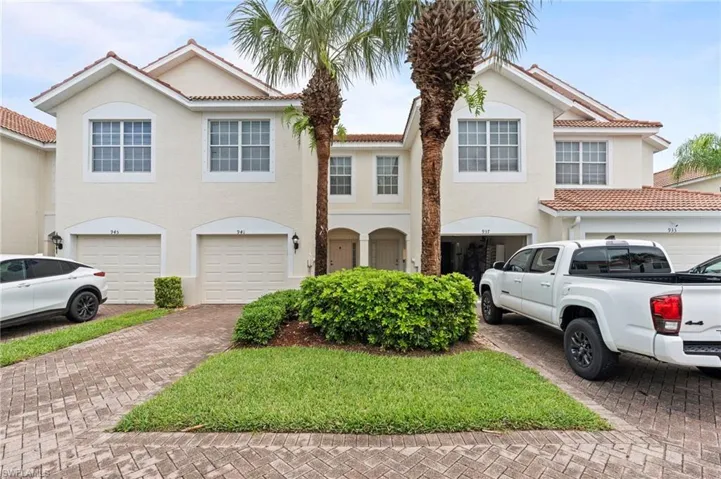 Mediterranean / spanish house with a tile roof, decorative driveway, stucco siding, and a garage