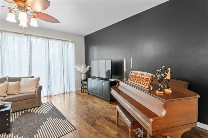 Living room featuring wood-type flooring and a ceiling fan