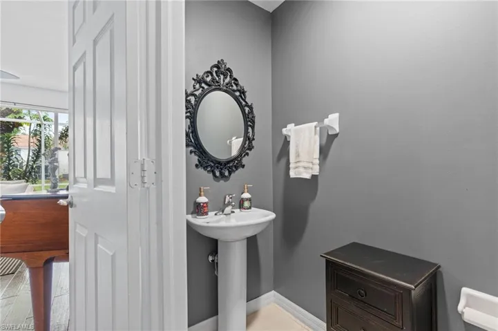 Half bath featuring baseboards and a sink
