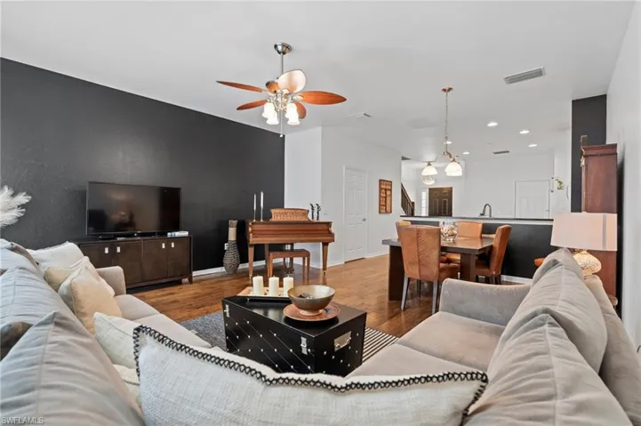 Living room featuring wood finished floors, ceiling fan, and recessed lighting