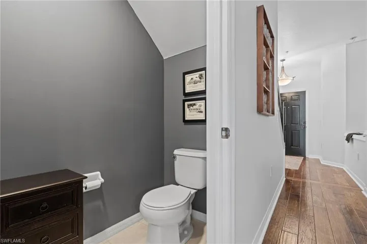 Bathroom with light wood finished floors and lofted ceiling