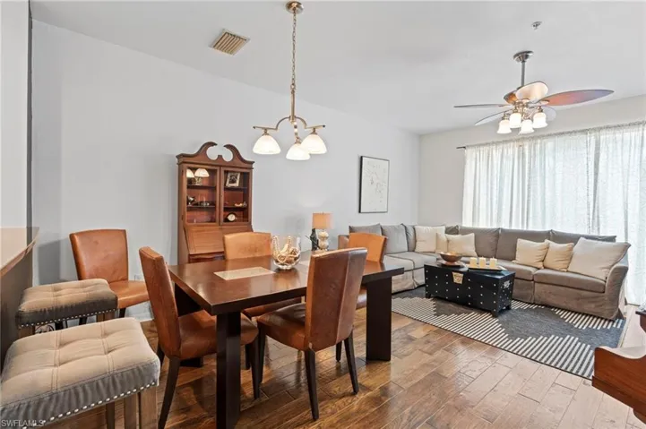 Dining area with wood-type flooring, ceiling fan, and suspended lighting