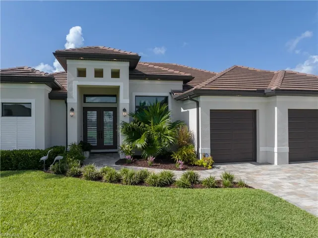 View of front of home featuring a garage, a front lawn, and french doors