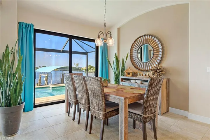 Tiled dining space featuring a notable chandelier