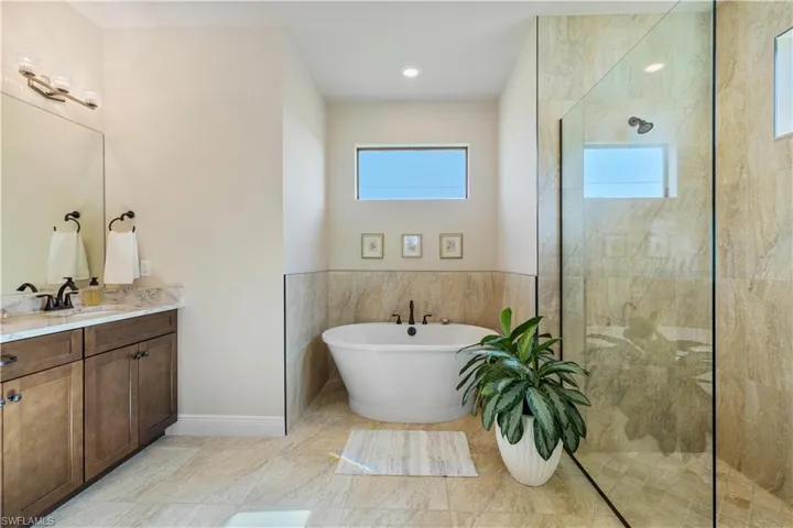 Bathroom with vanity, shower with separate bathtub, and tile patterned floors