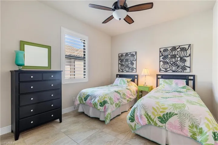 Bedroom with ceiling fan and light tile patterned floors