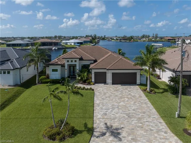 View of front facade featuring a water view, a garage, and a front yard