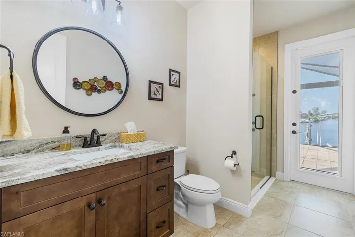 Bathroom with vanity, a water view, a healthy amount of sunlight, and an enclosed shower