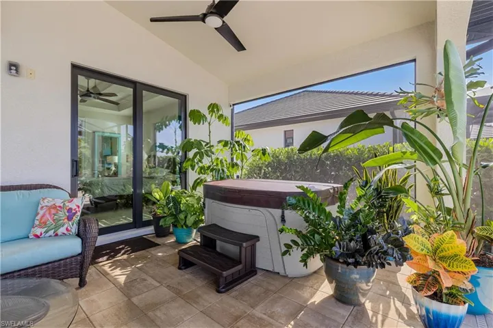 View of patio featuring ceiling fan and a hot tub