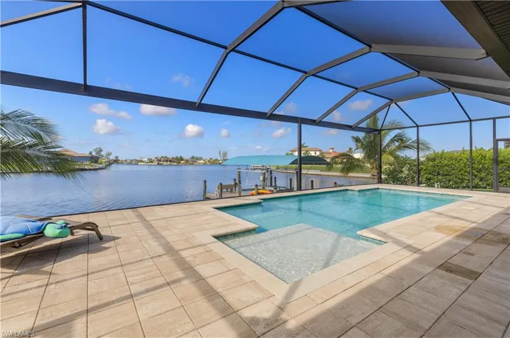View of pool with a lanai, a water view, and a patio area