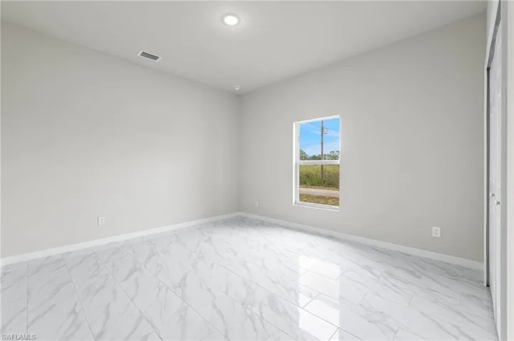 Bedroom 3 - large impact window for natural light along with patterned floor tiles.