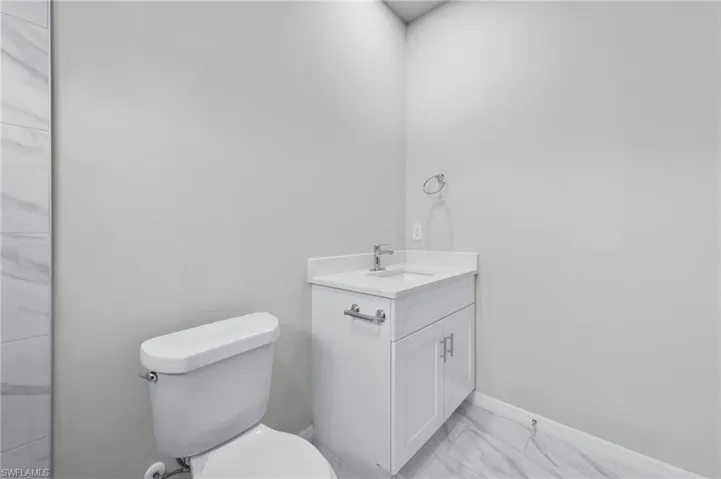 White quartz countertops with tub to ceiling tile.