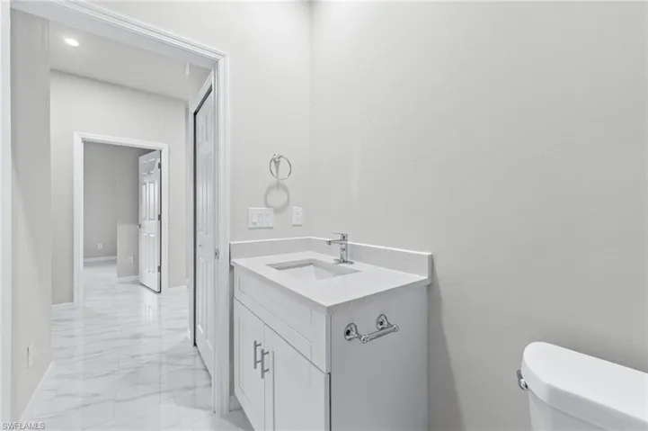 White quartz countertops with tub to ceiling tile.