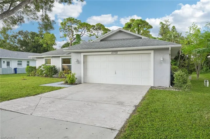 Ranch-style house with a garage and a front lawn